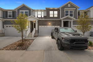 View of property with a garage, brick siding, and concrete driveway