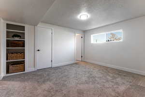 Unfurnished bedroom featuring baseboards, carpet flooring, and a textured ceiling