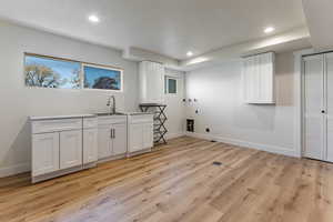 Laundry room featuring baseboards, cabinet space, hookup for a washing machine, and recessed lighting