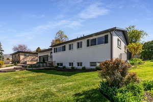 Back of property featuring brick siding and a yard