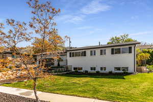 Tri-level home featuring brick siding, a front yard, and fence