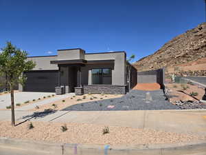 Contemporary home with stucco siding, a garage, and driveway