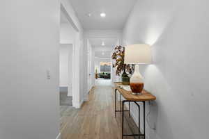 Hall with recessed lighting, baseboards, and light wood-type flooring
