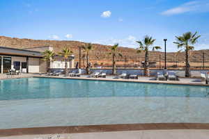 Community pool with a patio, fence, and a mountain view