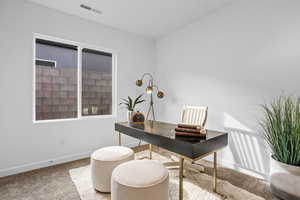 Carpeted office space featuring baseboards and visible vents