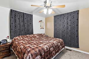 Bedroom with a ceiling fan and carpet