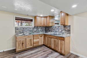 Kitchen featuring baseboards, wood finished floors, visible vents, and a sink