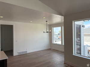 Unfurnished dining area with baseboards, visible vents, a chandelier, and dark wood-style flooring