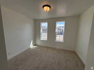 Carpeted spare room with baseboards and visible vents