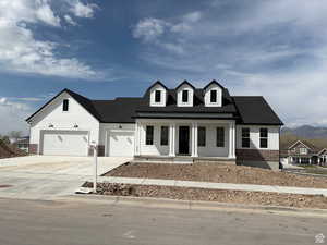 View of front of property with roof with shingles, driveway, covered porch, brick siding, and a garage