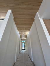 Hallway with wooden ceiling and baseboards