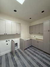 Laundry room with cabinet space, washer hookup, and recessed lighting