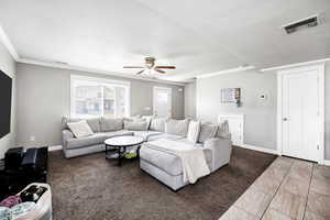 Living area with baseboards, visible vents, a ceiling fan, marble finish floor, and crown molding