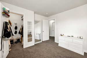 Bedroom with baseboards and dark carpet