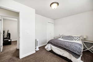 Bedroom featuring baseboards, carpet flooring, and a closet