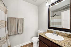 Full bathroom with vanity, baseboards, toilet, tile patterned flooring, and a shower with shower curtain