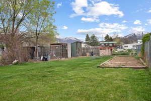 View of yard featuring a fenced backyard, a mountain view, and exterior structure