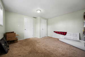 Unfurnished room featuring carpet, visible vents, and baseboards