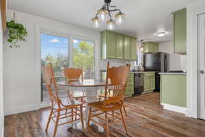 Dining room featuring baseboards, a chandelier, and dark wood-type flooring