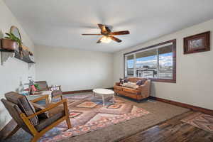 Living area with baseboards, a ceiling fan, and wood finished floors