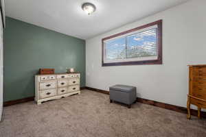 Bedroom featuring light carpet and baseboards