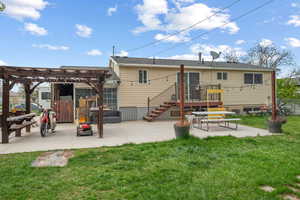 Back of property featuring fence, a pergola, a yard, and a patio