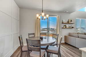 Dining room featuring baseboards, a chandelier, visible vents, and light wood-style flooring