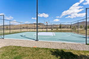 View of basketball court featuring community basketball court, a mountain view, and fence
