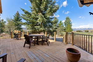 Wooden deck featuring outdoor dining area and a mountain view