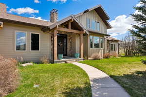 Craftsman inspired home with board and batten siding, a front lawn, and a chimney