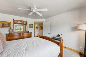 Carpeted bedroom with baseboards and ceiling fan