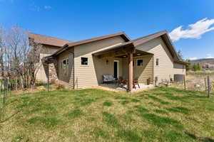 Back of property featuring a lawn, a patio, and central AC unit