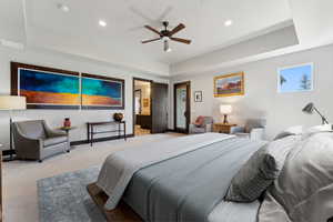 Carpeted bedroom featuring baseboards, visible vents, recessed lighting, and a raised ceiling