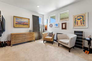 Sitting room with light carpet and recessed lighting