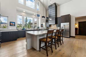Kitchen featuring plenty of natural light, high quality fridge, and a high ceiling