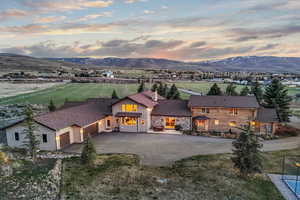 View of front of property with a chimney, aphalt driveway, board and batten siding, a mountain view, and a garage