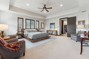 Bedroom featuring recessed lighting, a tray ceiling, visible vents, baseboards, and light colored carpet