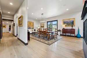 Dining space featuring light wood-type flooring, an inviting chandelier, baseboards, and recessed lighting