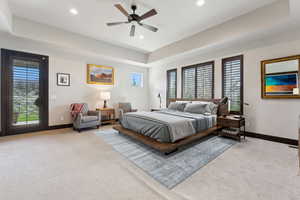 Bedroom with light carpet, baseboards, recessed lighting, and a tray ceiling
