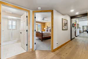 Hall featuring baseboards, log walls, visible vents, and light wood-style flooring