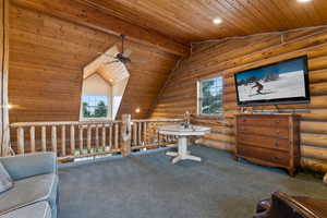 Interior space with plenty of natural light, a ceiling fan, wood ceiling, and log walls
