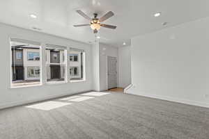Carpeted spare room with ceiling fan, baseboards, visible vents, and recessed lighting