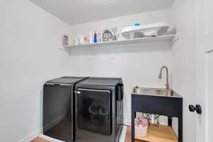 Washroom featuring washer and clothes dryer, light wood finished floors, and laundry area