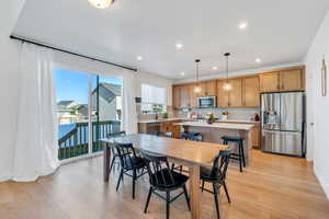 Dining area with baseboards, light wood-style floors, and recessed lighting