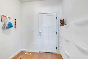 Entryway featuring baseboards, light wood-style flooring, and visible vents