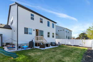 Rear view of house with fence, an outdoor living space, and a patio area