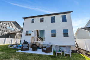 Back of property with a fenced backyard, a yard, and a patio