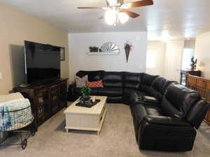 Living room featuring light colored carpet and ceiling fan
