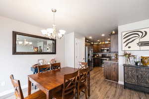 Dining room featuring recessed lighting, wood finished floors, baseboards, and a notable chandelier
