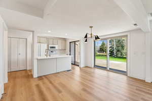 Kitchen featuring light countertops, visible vents, white appliances, baseboards, and light wood-style flooring